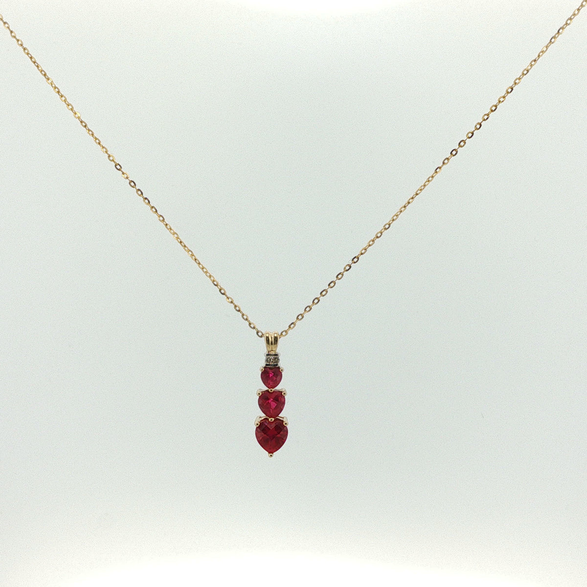 Three-Stone Heart Ruby Pendant Necklace in Yellow Gold